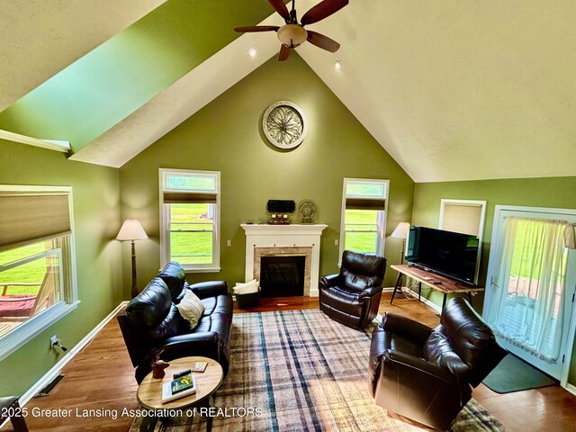 8464 W Howe Rd, Eagle, MI 48822 - living room featuring ceiling fan, vaulted ceiling, a fireplace, and baseboards