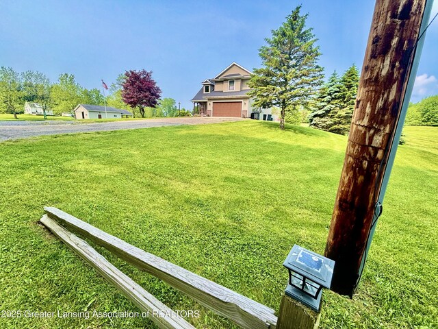 8464 W Howe Rd, Eagle, MI 48822 - view of green lawn with asphalt driveway and an attached garage