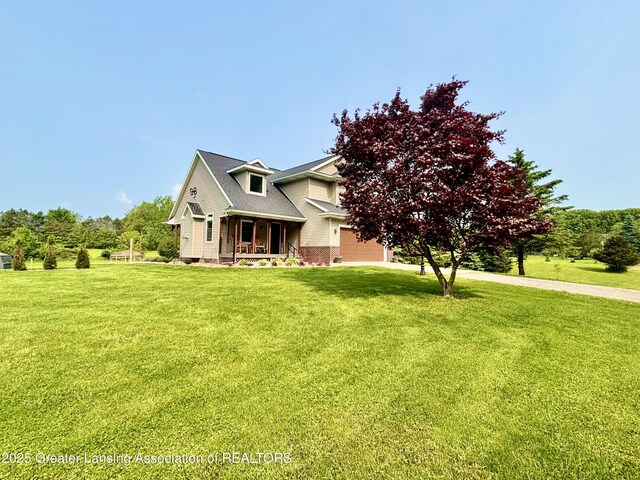 8464 W Howe Rd, Eagle, MI 48822 - view of front facade with a front lawn, covered porch, and a garage