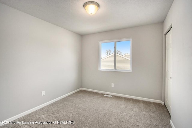 3012 Moccasin Dr, Dewitt, MI 48820 - empty room featuring carpet flooring, baseboards, and visible vents