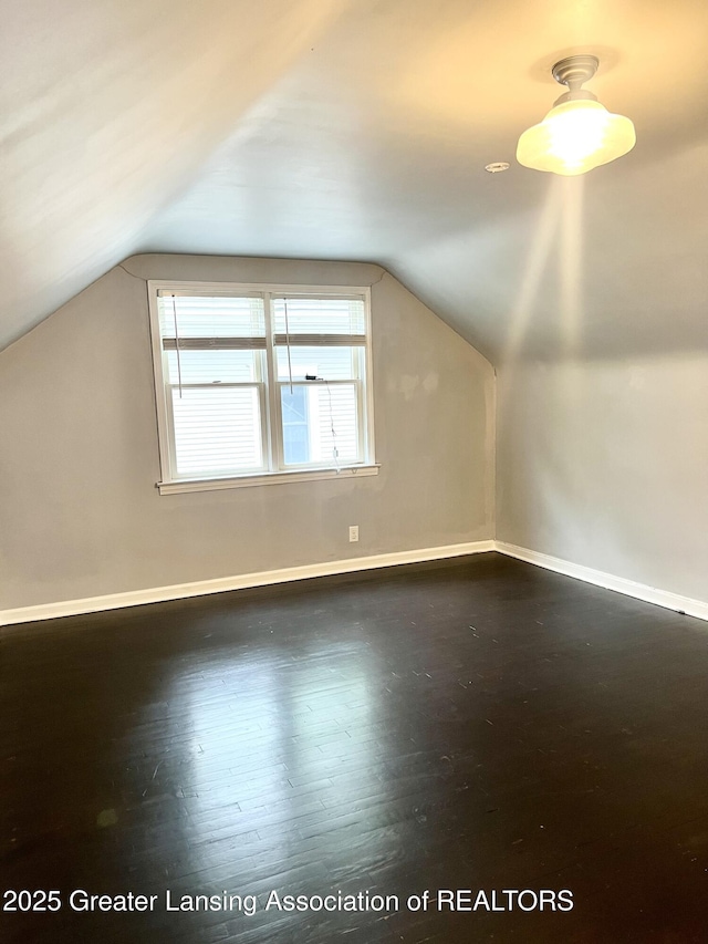 909 Britten Ave, Lansing, MI 48910 - bonus room featuring lofted ceiling, baseboards, and dark wood finished floors