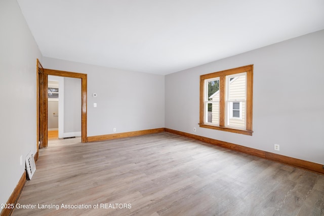 unfurnished room featuring baseboards, visible vents, and light wood finished floors