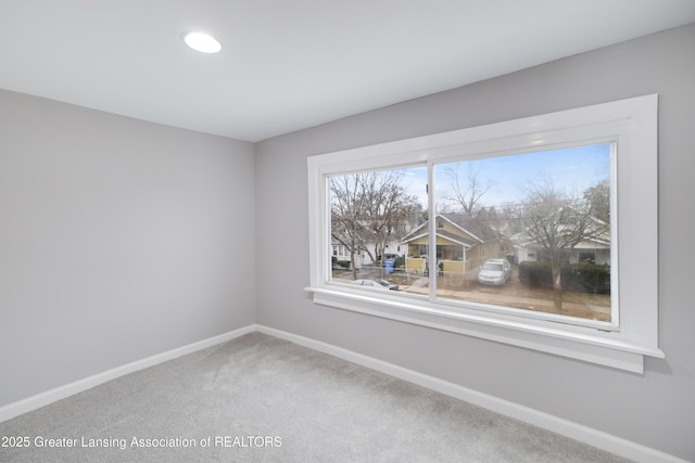 spare room featuring baseboards and carpet flooring