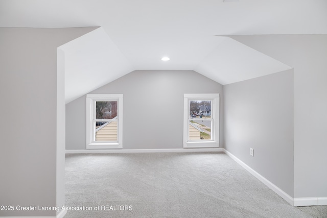additional living space featuring baseboards, vaulted ceiling, and carpet flooring