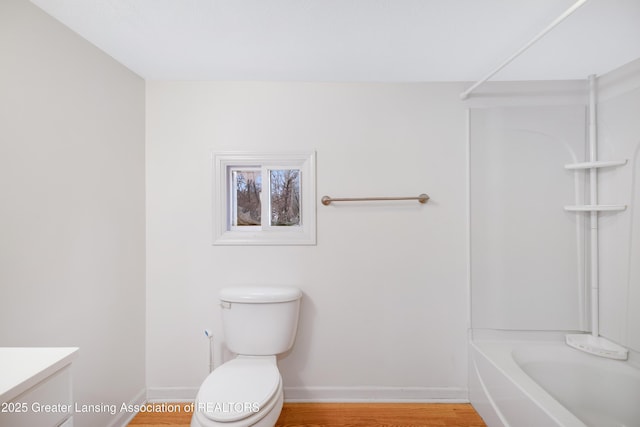 full bathroom with vanity, toilet, baseboards, tub / shower combination, and wood finished floors