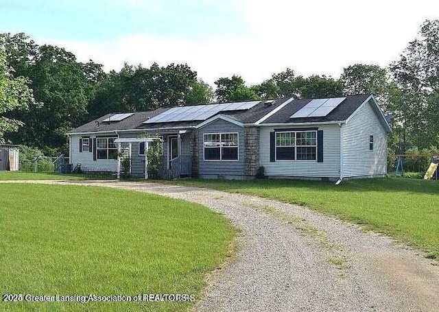 464 N Rolland Rd, Weidman, MI 48893 - ranch-style house with a front yard, curved driveway, and solar panels