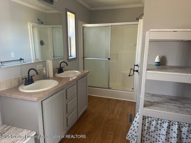 464 N Rolland Rd, Weidman, MI 48893 - bathroom featuring a shower stall, wood finished floors, ornamental molding, and a sink