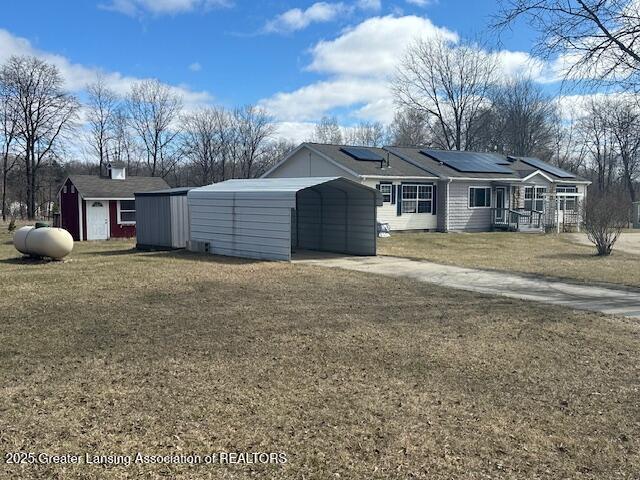 464 N Rolland Rd, Weidman, MI 48893 - exterior space with solar panels, a lawn, an outbuilding, a shed, and a carport