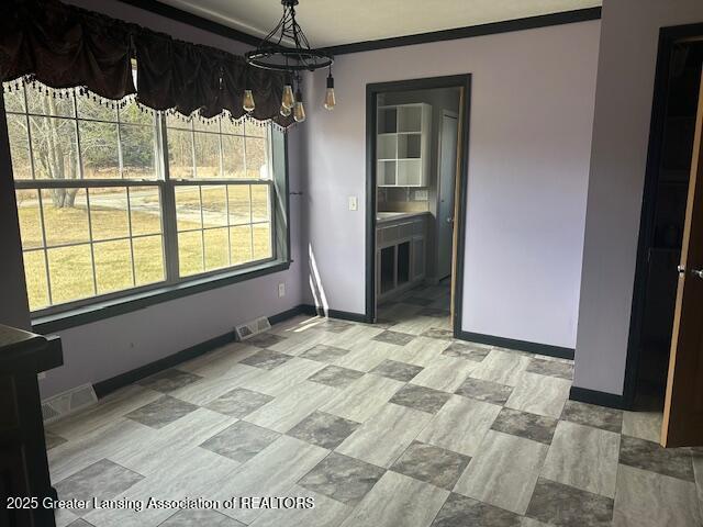 464 N Rolland Rd, Weidman, MI 48893 - unfurnished dining area with ornamental molding, baseboards, a notable chandelier, and visible vents