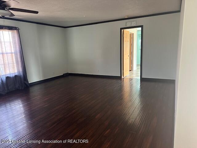 464 N Rolland Rd, Weidman, MI 48893 - empty room with ornamental molding, dark wood-type flooring, a textured ceiling, and ceiling fan