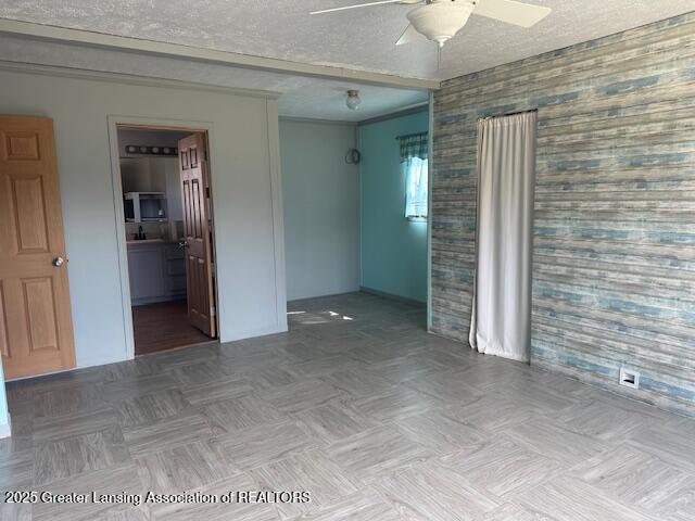 464 N Rolland Rd, Weidman, MI 48893 - spare room with a textured ceiling, wallpapered walls, and a ceiling fan