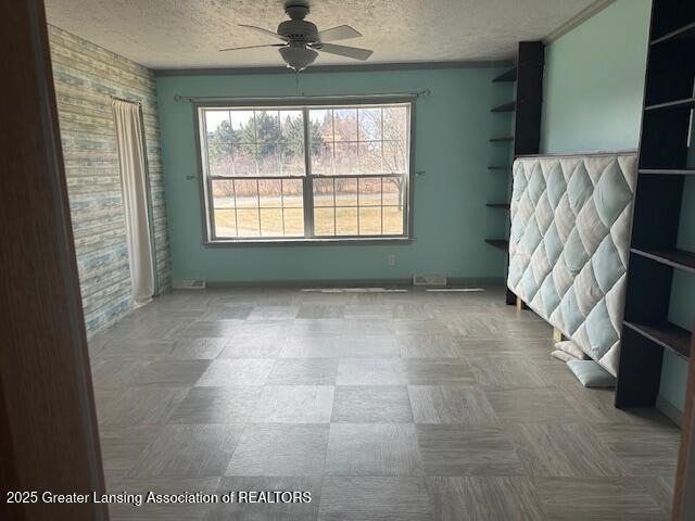 464 N Rolland Rd, Weidman, MI 48893 - empty room featuring a textured ceiling, a ceiling fan, and ornamental molding
