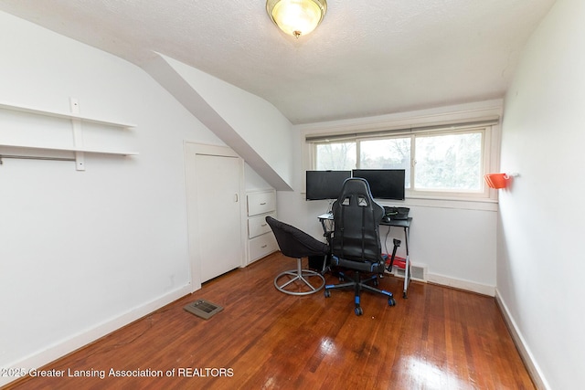 home office featuring wood finished floors, baseboards, and lofted ceiling