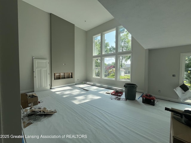 11350 Traverse Dr, Grand Ledge, MI 48837 - carpeted living room featuring high vaulted ceiling and baseboards