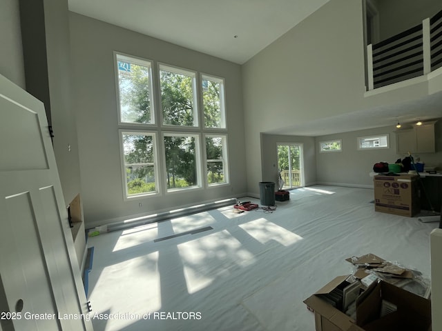 11350 Traverse Dr, Grand Ledge, MI 48837 - unfurnished living room featuring high vaulted ceiling and carpet