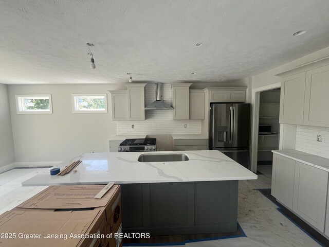 11350 Traverse Dr, Grand Ledge, MI 48837 - kitchen featuring stainless steel fridge, wall chimney range hood, tasteful backsplash, a textured ceiling, and light stone counters