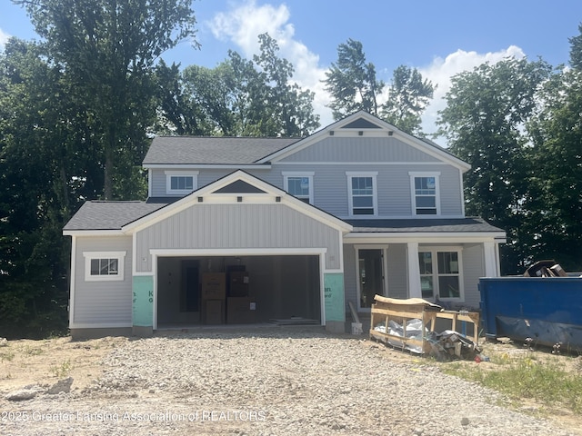 6764 Abbey Ln, Grand Ledge, MI 48837 - view of front facade featuring covered porch, a garage, gravel driveway, and roof with shingles