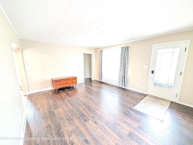 foyer featuring wood finished floors, baseboards, visible vents, arched walkways, and ornamental molding
