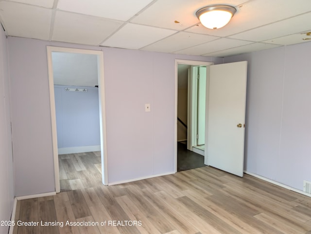unfurnished bedroom featuring a closet, visible vents, wood finished floors, a paneled ceiling, and a spacious closet