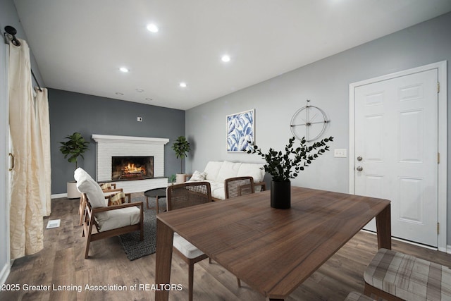 dining space featuring recessed lighting, wood finished floors, visible vents, and a fireplace