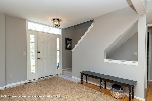 foyer featuring baseboards and wood finished floors