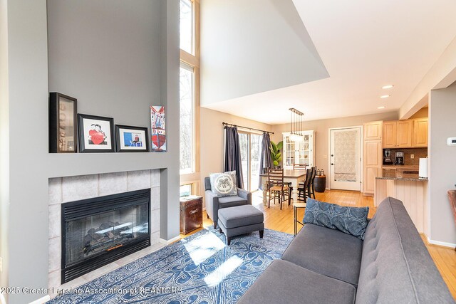 living room with a fireplace, light wood-type flooring, and recessed lighting