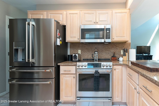 kitchen with light stone countertops, decorative backsplash, tile patterned floors, light brown cabinetry, and appliances with stainless steel finishes
