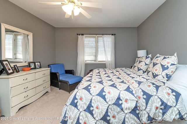 bedroom with ceiling fan and light colored carpet