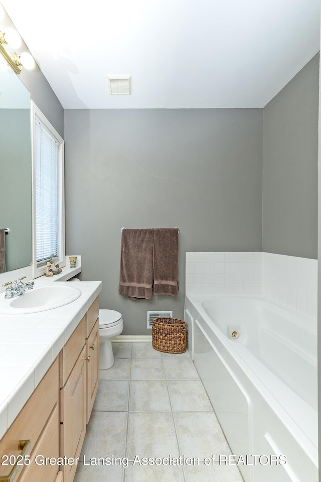 full bath featuring tile patterned flooring, toilet, a bath, vanity, and visible vents