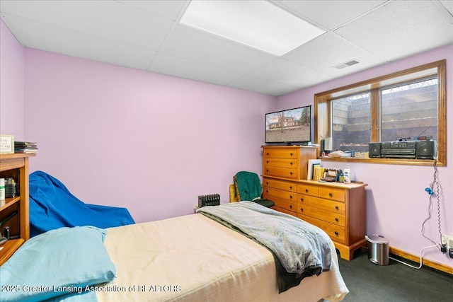 bedroom with baseboards, carpet flooring, visible vents, and a paneled ceiling
