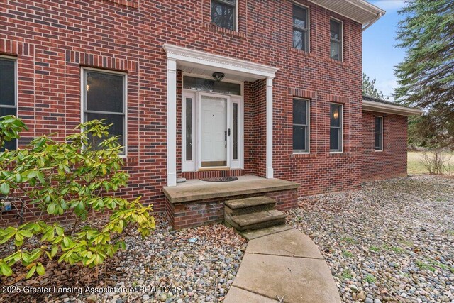 view of exterior entry with brick siding
