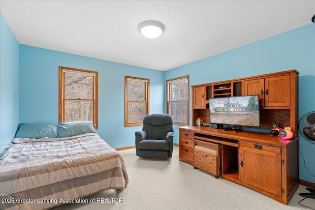 bedroom featuring baseboards and light carpet