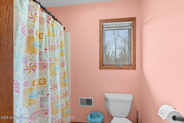 full bathroom with visible vents, toilet, and a shower with shower curtain