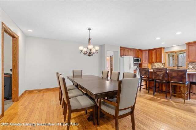 dining room with recessed lighting, a notable chandelier, baseboards, and light wood-type flooring