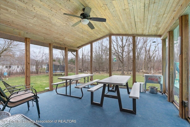 sunroom featuring floor to ceiling windows, wood ceiling, and a ceiling fan