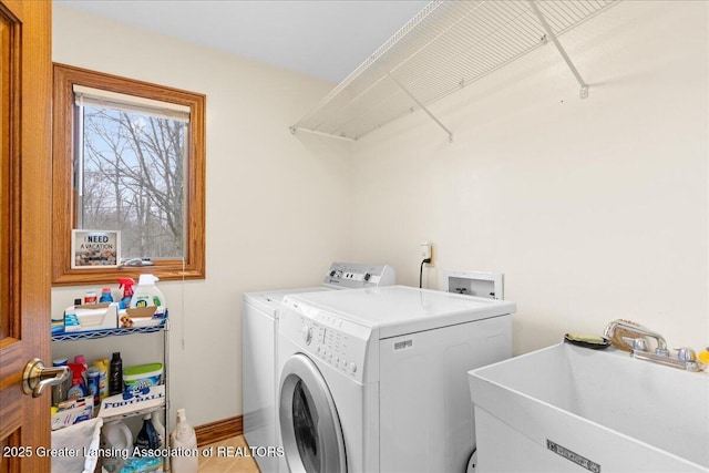 clothes washing area with separate washer and dryer, laundry area, and a sink