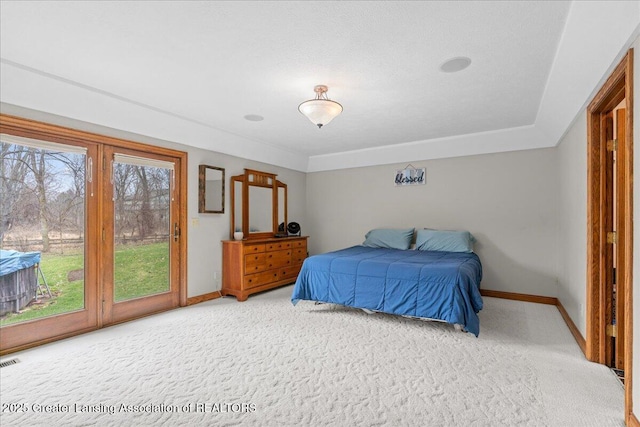carpeted bedroom featuring access to outside, baseboards, and visible vents