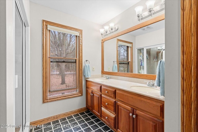 bathroom featuring double vanity, a sink, and baseboards