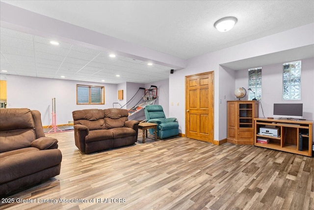living room featuring baseboards, wood finished floors, and recessed lighting