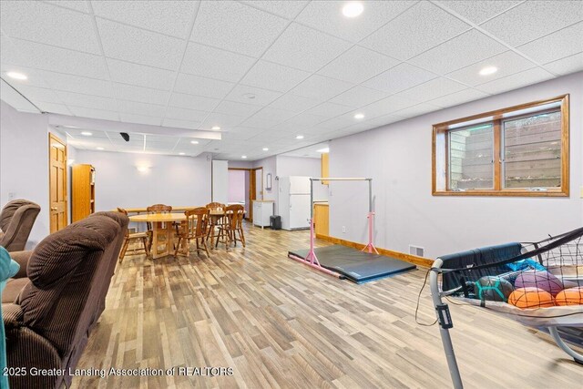 exercise area featuring recessed lighting, baseboards, light wood finished floors, visible vents, and a paneled ceiling