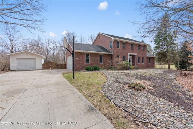 view of front of home featuring driveway, a detached garage, and brick siding
