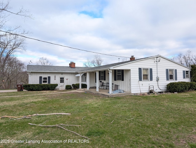 12302 Sandborn Rd, Portland, MI 48875 - rear view of house featuring a yard, board and batten siding, and a chimney