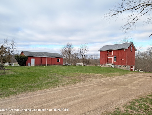 12302 Sandborn Rd, Portland, MI 48875 - view of yard with driveway, an outbuilding, a garage, fence, and a pole building