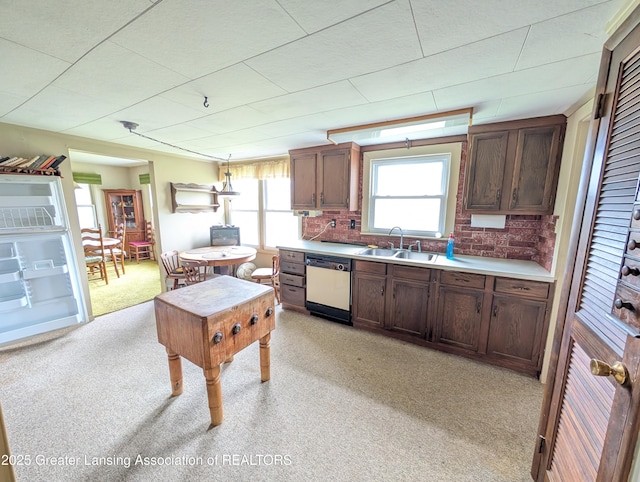 12302 Sandborn Rd, Portland, MI 48875 - kitchen featuring pendant lighting, dishwasher, a sink, light countertops, and light carpet