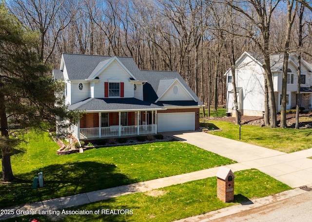traditional home with concrete driveway, a porch, a front yard, and a garage