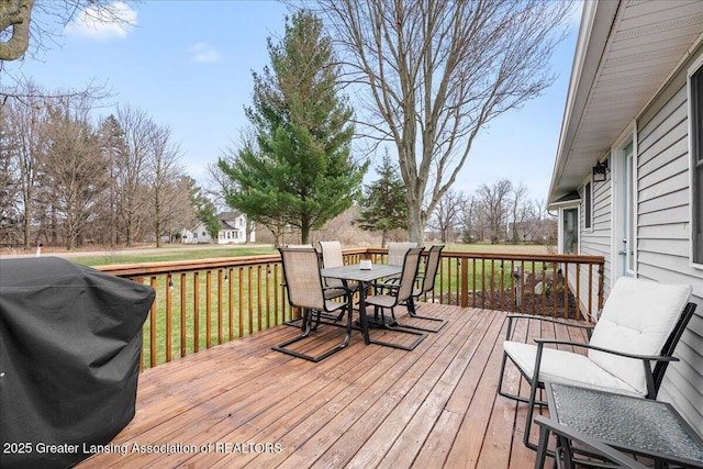 wooden deck with a yard, a grill, and outdoor dining space