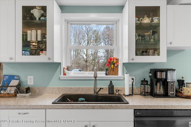 kitchen featuring glass insert cabinets, white cabinets, a sink, and black dishwasher