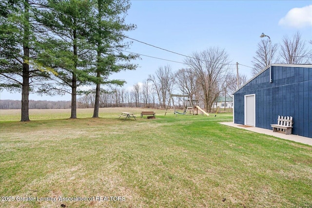view of yard featuring an outbuilding and playground community