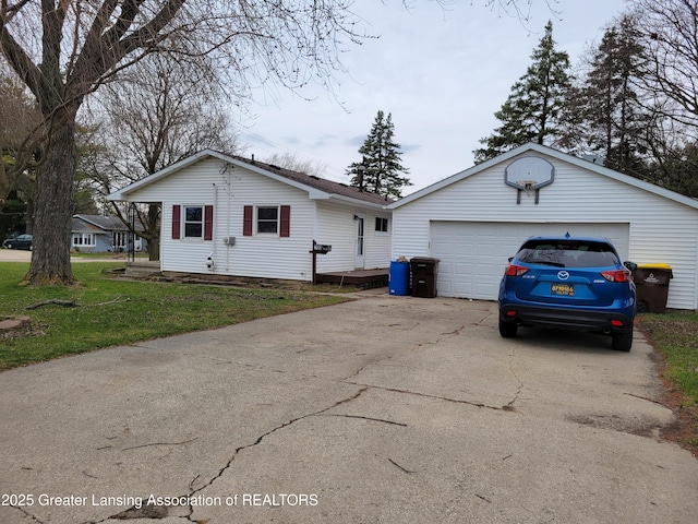 single story home with a detached garage and a front lawn