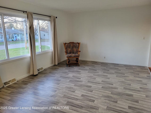 sitting room featuring baseboards, visible vents, and wood finished floors
